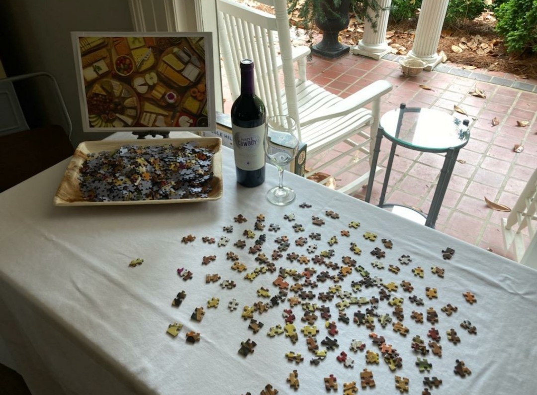 A bottle of wine and a puzzle out on the patio